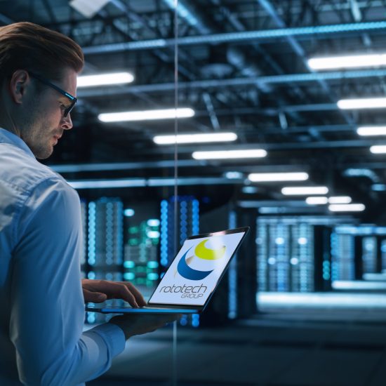 Back View of Male Specialist Using Laptop in Big Data Center Office. High Speed Data Transfer, Server Transfer, Technology Science Breakethrough, Progress, Innovation Concept